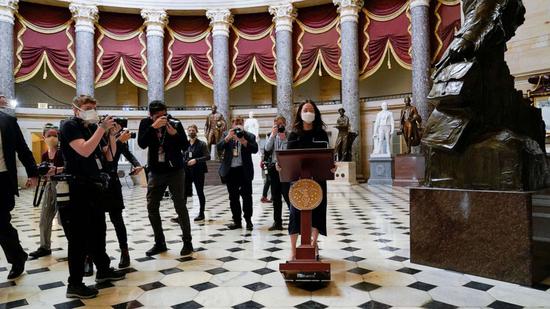 工作人员推着佩洛西的讲话台入场(美联社)